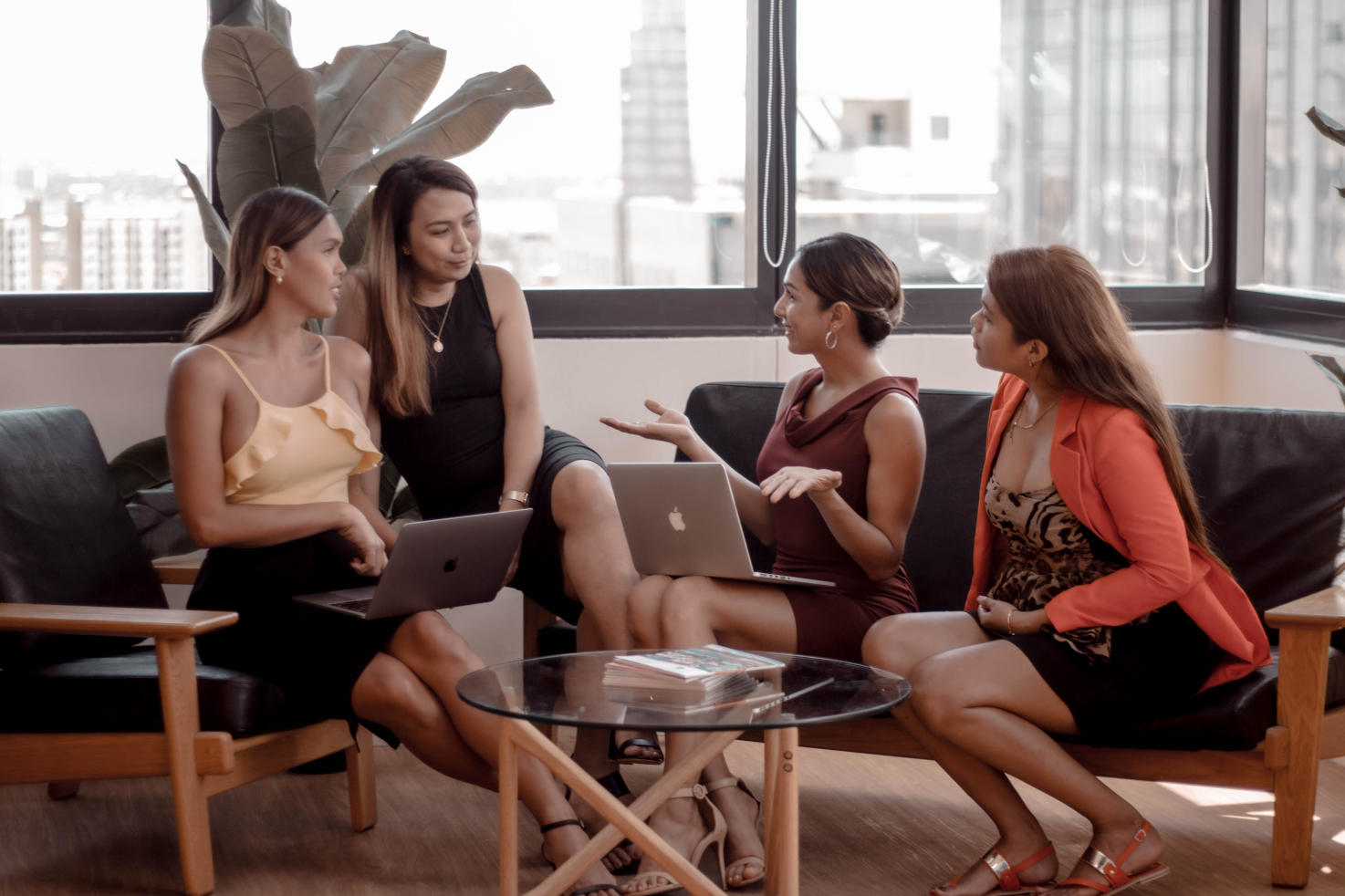 Maki working with fellow ladyboy team members at the office Four team members of My Ladyboy Date, including Maki Gingoyon, sitting together with laptops and discussing ways to improve the dating experience.