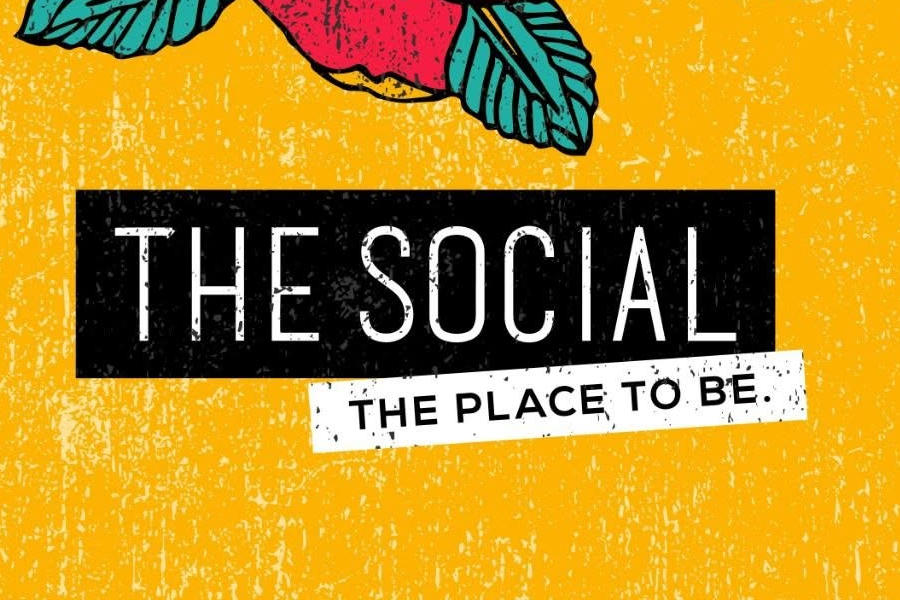 Logo of the social featuring bold black and white lettering on a textured yellow background with the slogan “The Place to Be.”